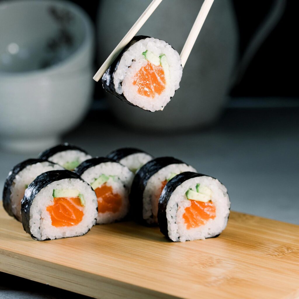Chopsticks holding a sushi roll